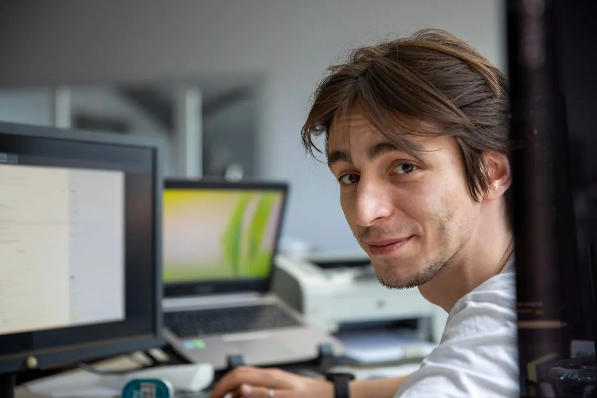 Medewerker werkt geconcentreerd achter twee beeldschermen
