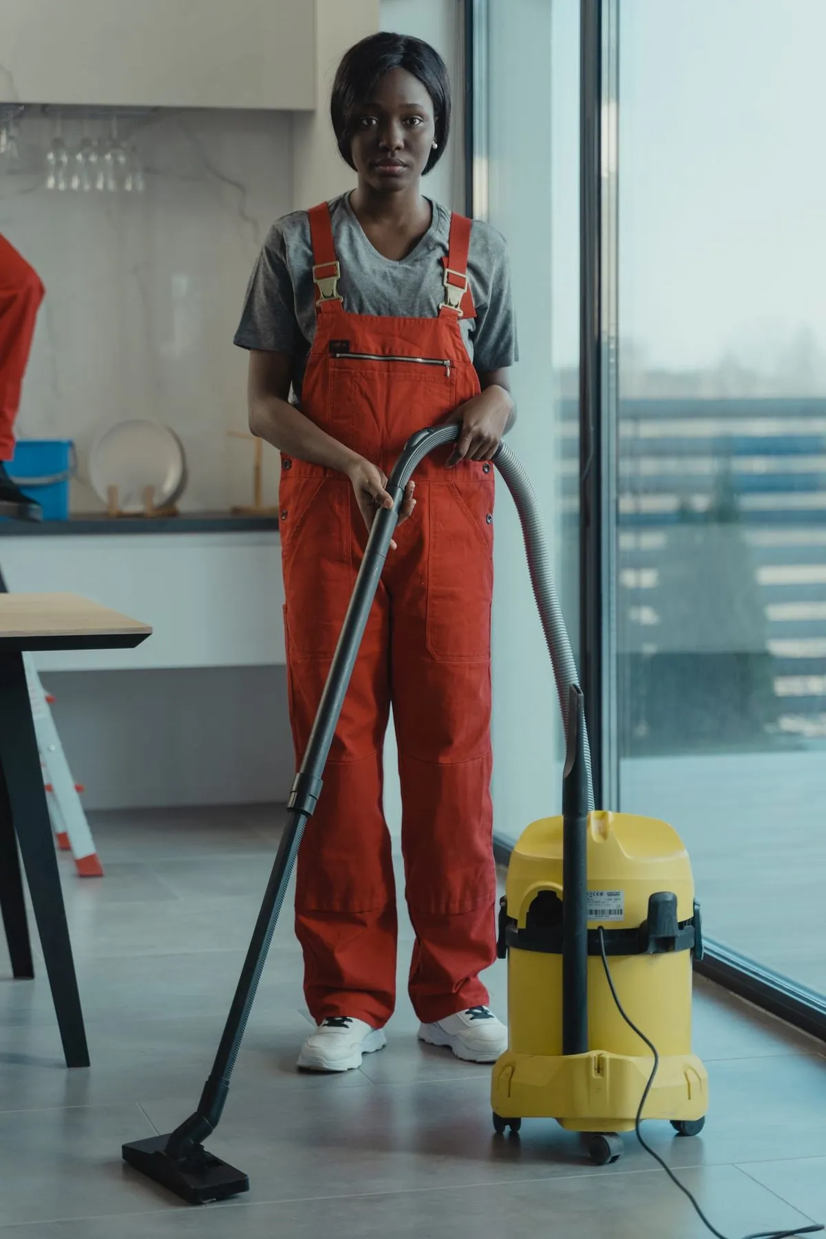 Een professionele schoonmaker stofzuigt een moderne binnenruimte
