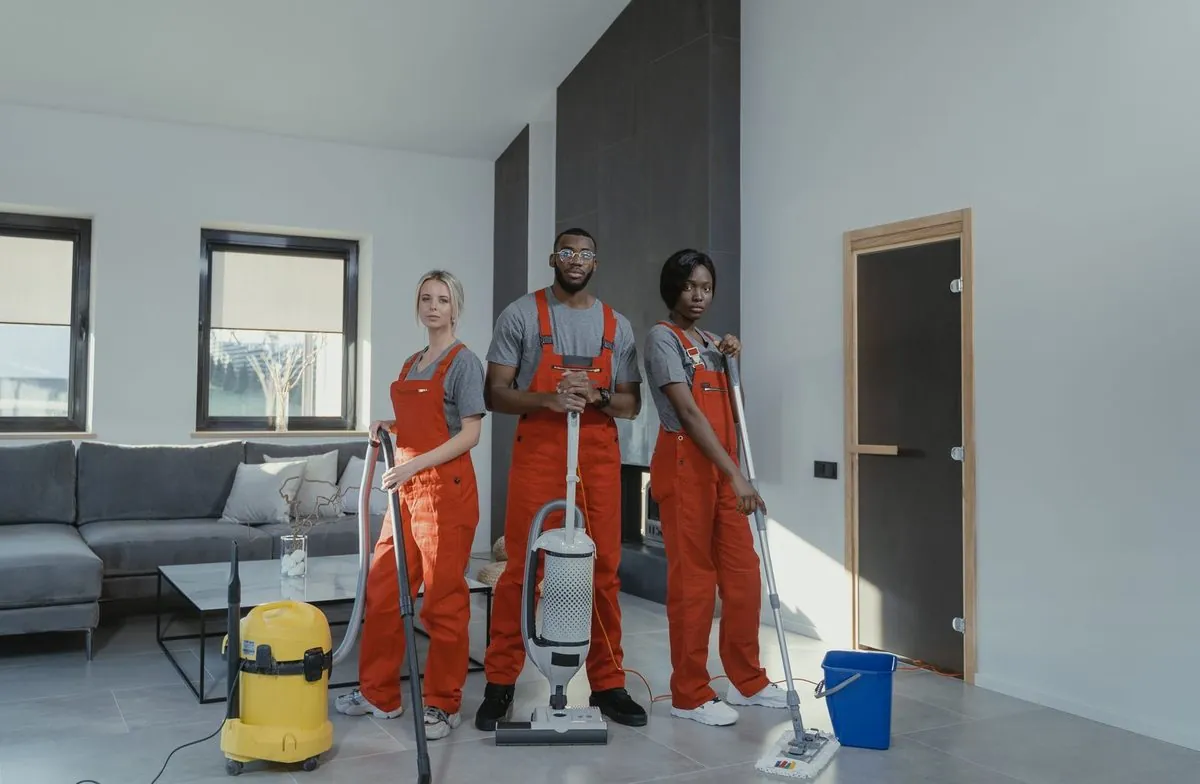 Een divers schoonmaakteam in uniform staat klaar met materiaal
