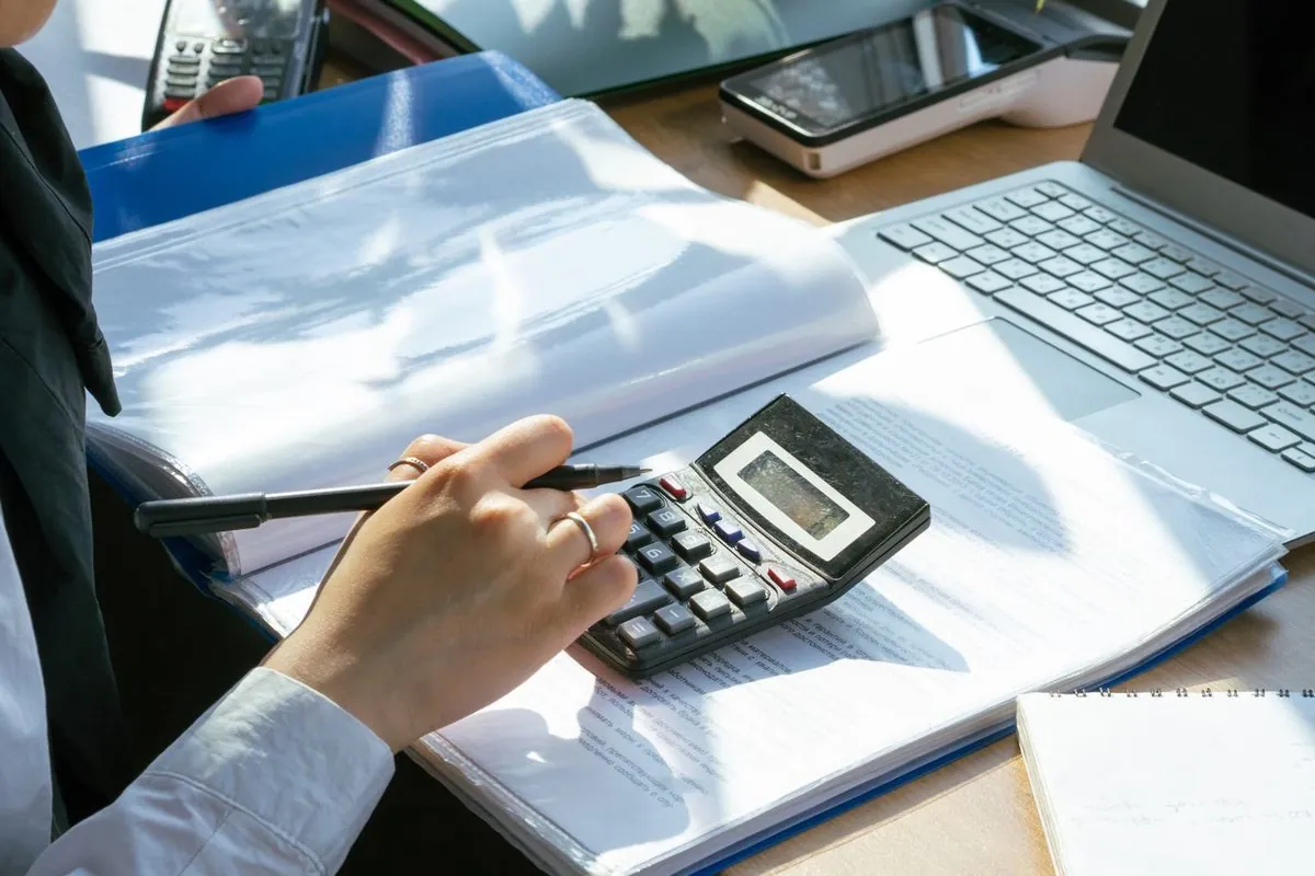 Een persoon maakt financiële berekeningen met een rekenmachine