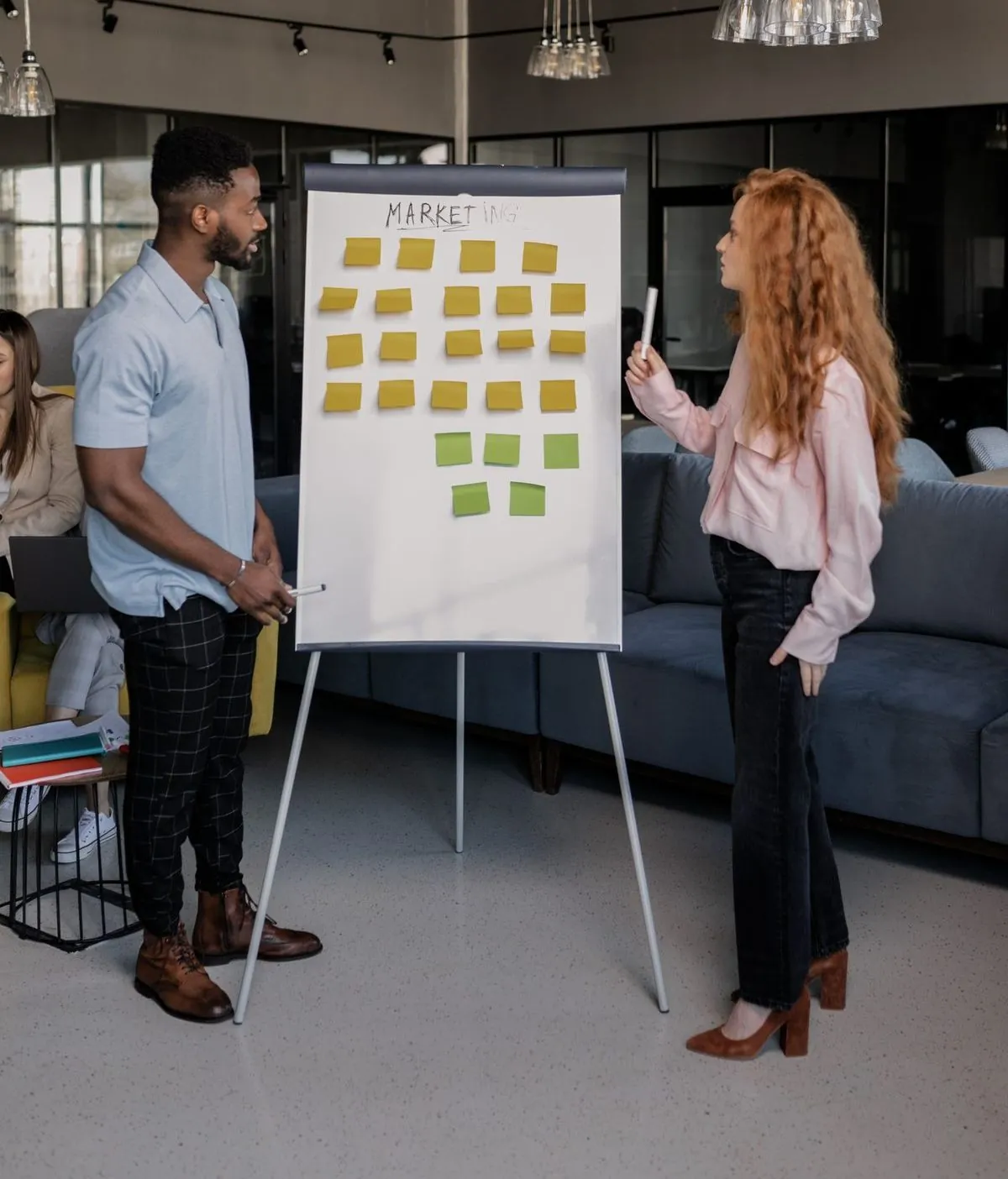 Twee collega's bespreken een aanpak met sticky notes voor een whiteboard