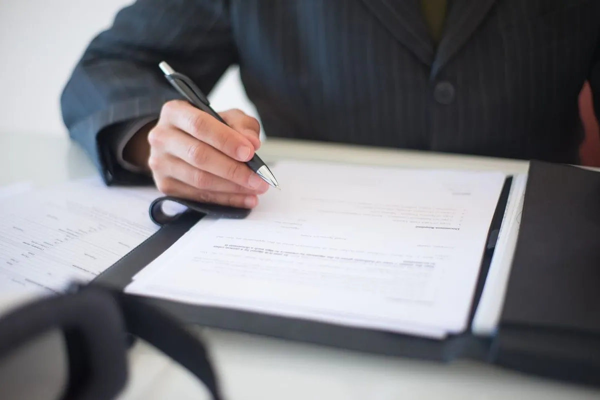Close-up van een hand die een zakelijk contract ondertekent