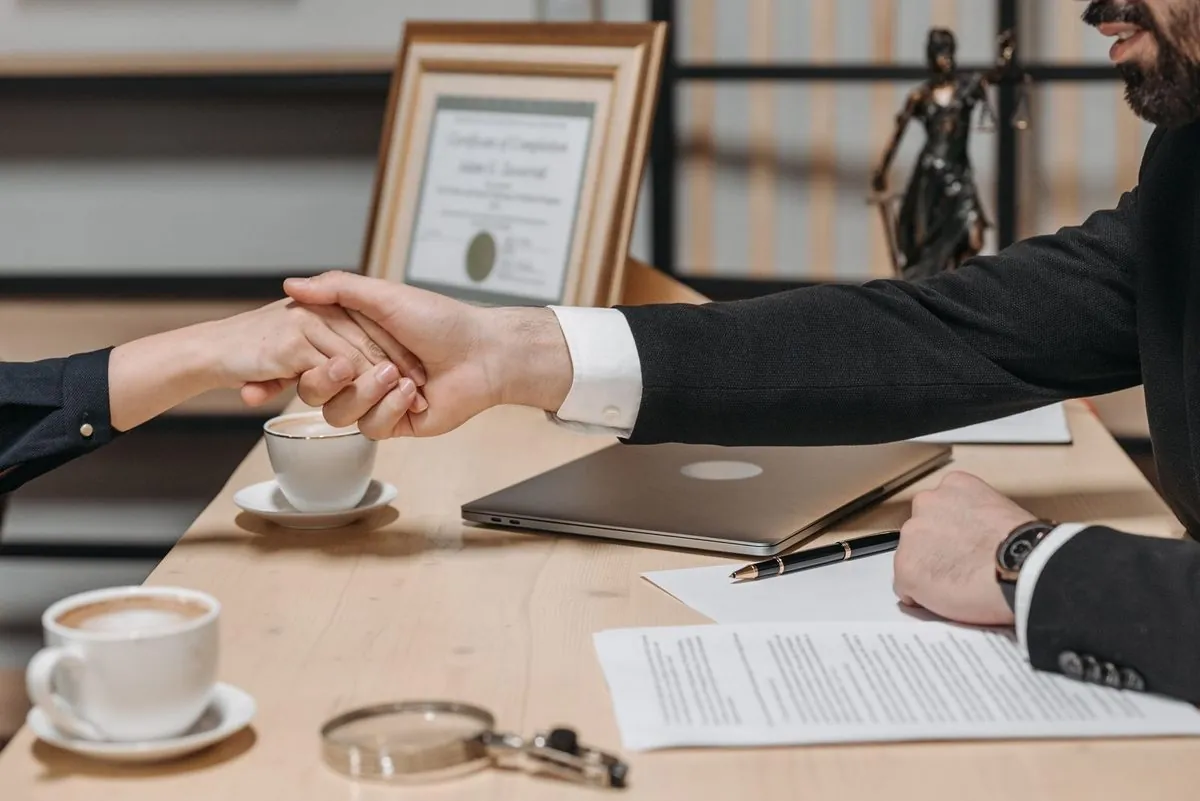 Twee zakenmensen bezegelen een getekend contract met een handdruk