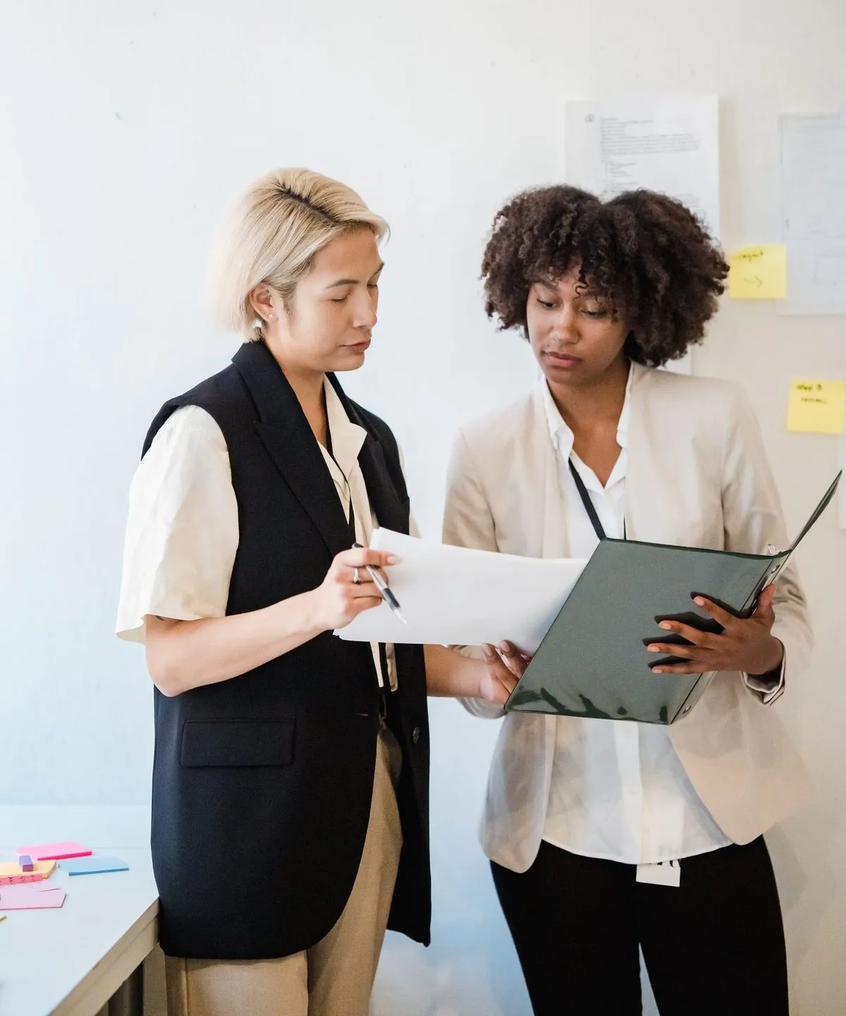 Twee professionals bekijken samen een document in warm licht