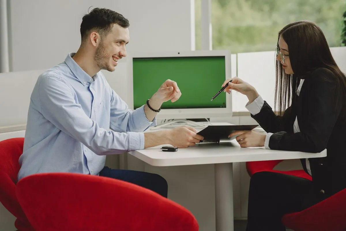 Twee collega's overleggen samen aan een bureau